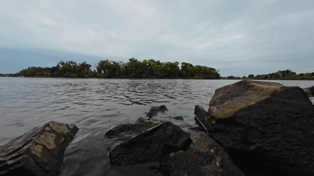 Low-Angle View of Sacramento River with Levee Riprap on a Cloudy Autumn Day