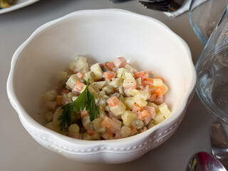 Close-up of Olivier salad with diced vegetables and ham. Homemade cooking, family celebration and comfort through traditional festive food.