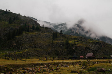 Fototapeta premium Mountains shrouded in fog and clouds in Altai, Russia