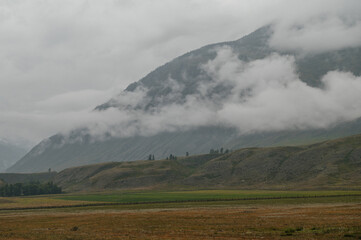 Obraz premium Mountains shrouded in fog and clouds in Altai, Russia