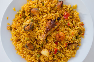 Paella con frutti di mare e gamberetti in piatto bianco