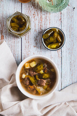 Spicy mexican soup with meat and jalopenos in a bowl top and vertical view