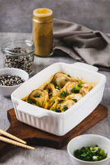 One-Pan Baked Dumplings with Herbs and Sauce in a Pan on the Table vertical view