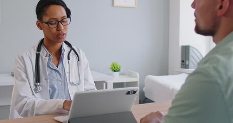 Doctor explains diagnosis to patient during clinic consultation during exam. Physician outlines medical plan and discusses symptoms and treatment with health care guidance. Medicine concept. - Powered by Adobe