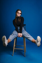 A Trendy and Colorful Portrait Showcasing a Young Woman Sitting Comfortably on a Stylish Stool