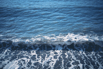 Dark Blue Ocean Wave Breaking on Shore with Sea Foam Texture
