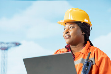 Smiling offshore platform crew member configuring boat management systems for more efficient oil extraction. Happy woman working on drilling rig doing seabed analysis using laptop