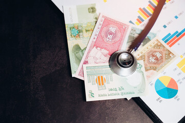 Currency and Healthcare Concept with Stethoscope on Financial Documents and Banknotes in Background...