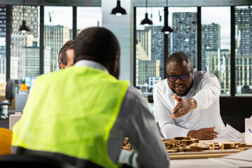 Real estate professionals using architectural software to refine housing layouts and 3D models. Development team collaborates on zoning regulations and property investment strategies.