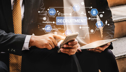 Two professionals focus on their devices, illustrating modern recruitment tactics. The image...