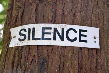 SILENCE Sign on a tree in a mountain forest