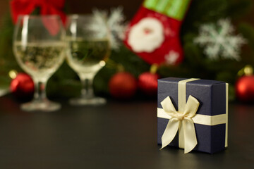 Festive Blue Gift Box with golden ribbon with Christmas Decor and Champagne