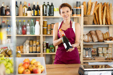 Portrait of female seller offering to buy champagne for a festive table