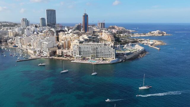 Midday 4K drone sweep over St Julian Portomaso, Malta: turquoise marina, yachts, curved waterfront and skyline &mdash; perfect for travel, real estate, luxury lifestyle and broadcast use