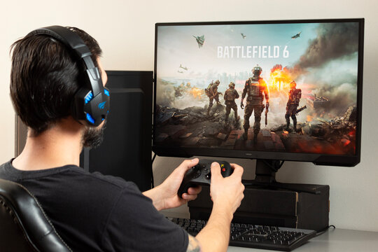 A man holding a xbox controller and using gamer earphones playing Battlefield 6 shooter video game
