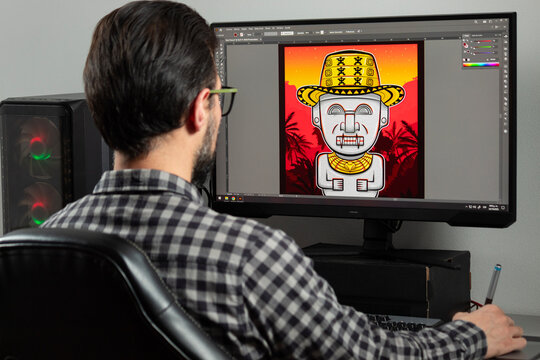 a graphic designer man backward designing an illustration into adobe illustrator sofware in a gamer computer