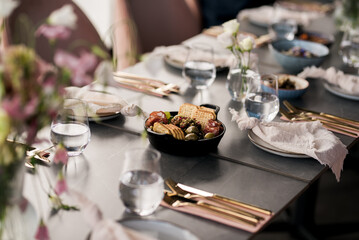 A beautifully arranged dining table with elegant decor, gold cutlery, and a charcuterie platter — perfect for a stylish gathering or celebration meal.