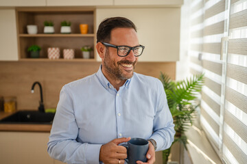 Man drinking coffee in kitchen enjoying morning break