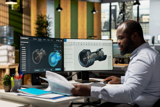 Technician in office reading wind turbine component documentation files to improve alternative energy efficiency. Researcher looking over paperwork documents to refine turbine part design