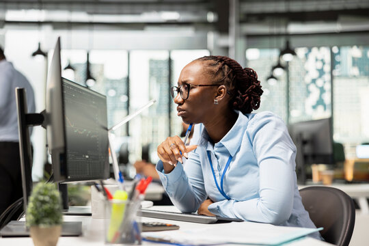 Brokerage company portfolio manager reviews asset performance and adjusts holdings. Financial specialist oversees diversified investment portfolios on PC to maximize returns for clients