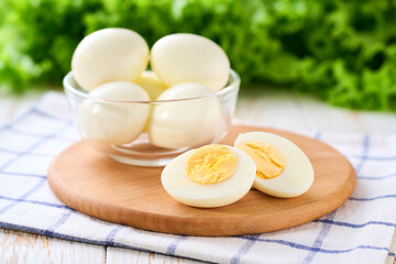 boiled chicken eggs peeled and cut in half on a white table, selective focus.