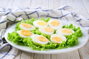 fresh hard boiled eggs halved on a white table, selective focus.