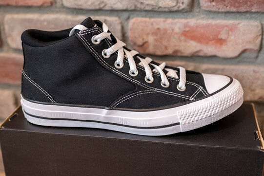 Calgary, Alberta - October 26, 2025: Converse All Star lace up shoes with box and brick background.