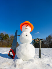 Obraz premium Snowman with winter hat and scarf outdoors. Snowman in winter landscape. Snowman with snowball fun outdoors.