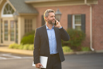 Real estate agent front of a new house. Realtor estate agent shows residential building in suburbs....