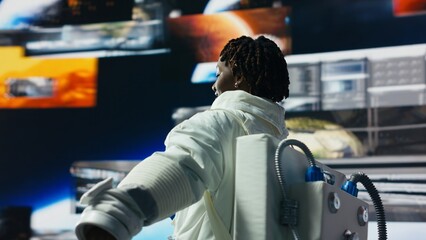 Cheerful astronaut dancing while surrounded by Mars planetary data on displays in spacecraft. Jolly starship cosmonaut doing funny dance moves, research data on digital backdrop, camera B