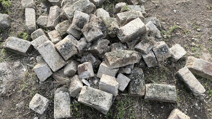 Old Weathered Brick Paving Stones Piled on Earth in Outdoor Garden Setting
