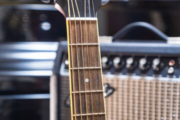 guitar fretboard close up in front of guitar amplifier in recording studio. guitar close up in studio for music production, recording
