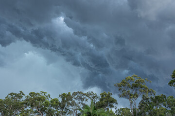 Strange, dark, storm clouds forming in a grey, leaden sky and making interesting shapes taking on a...