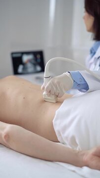 Doctor woman with white medical gloves performing ultrasound examination on patient's back