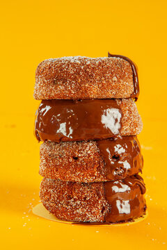 Chocolate sugared with melted icing and filling brioche doughnuts stacked.