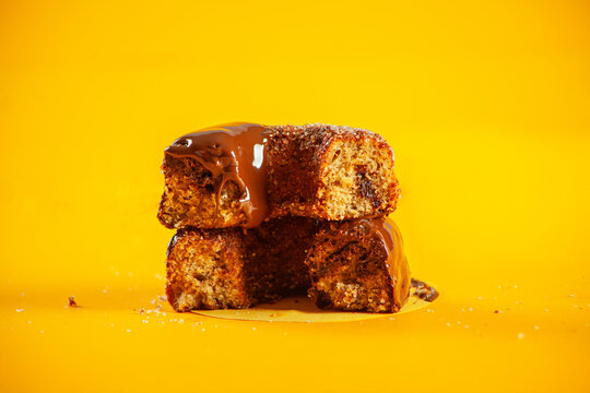 Chocolate sugared with melted icing and filling brioche doughnuts cut from the middle showing inside filling.