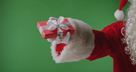Santa Claus in a red suit with a white fur cuff and glove holding a gift box against a green background. Perfect for Christmas banners, cards, and holiday advertising.