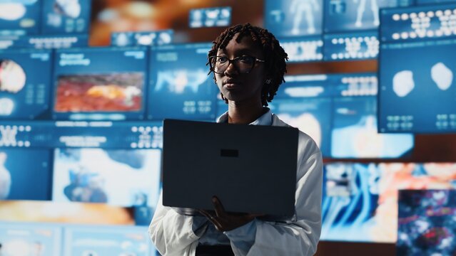 Epidemiologist reviewing viral mutation models on notebook screen. Scientist analyzing 3D virus structure on laptop to support vaccine development, surrounded by medical dashboards, camera B