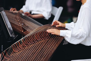 Traditional Korean folk musical instrument Gayageum, female orchestra band performing concert on Kayagum in of Seoul, South Korea, wooden zither with 12 strings, Koto or Guzheng live music performance © tsuguliev