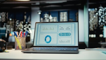 Empty corporate boardroom at night with digital display of performance metrics, graphs and...