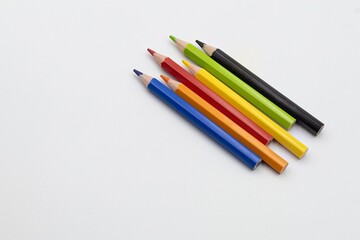 Colored pencils creating a diagonal pattern on white background