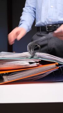 vertical video Person organizing documents in office binder, searching paperwork