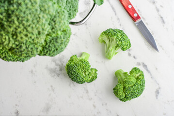 Raw broccoli in a white enamel colander