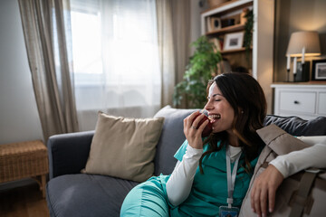 Healthcare worker relaxing at home eating healthy apple