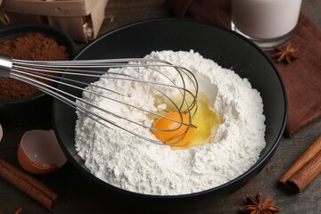 Ingredients for dough and whisk on wooden table, closeup