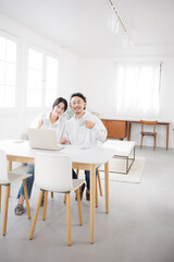 A couple in a beautiful living room, facing the camera—the image of a happy marriage, full-length.