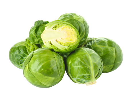 Pile of green, leafy Brussels sprouts with one sliced open against a black background, showing internal structure