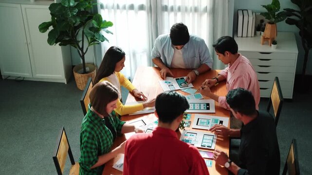 Top view of developer team designing Ux Ui design for phone interface or planning for making digital development. Startup project send develop plan to manager while sitting at boardroom. Convocation. - Powered by Adobe