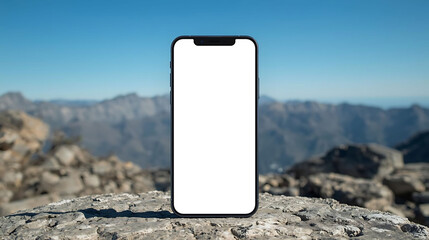 Front view smartphone with blank white screen on rocky mountain background and blue sky