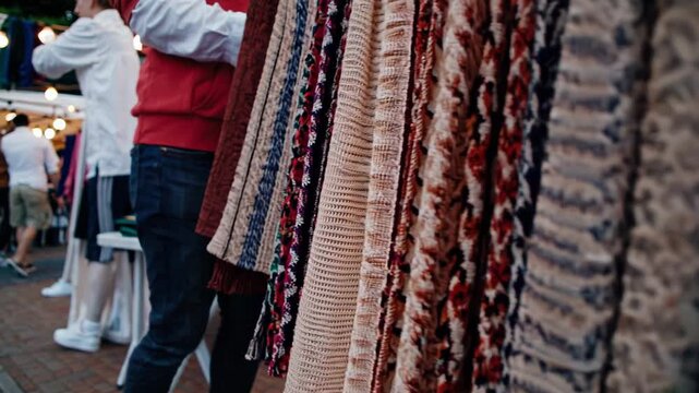 vivid scarves sway at bustling bazaar, brightly patterned scarves move amidst lively market sights, vibrant scarves with bold stripes sway in busy marketplace scene